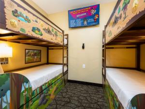 鸽子谷Country Cascades Waterpark Resort的墙上有标牌的房间,设有两张双层床