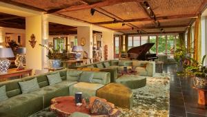 布尔格BLEICHE RESORT & SPA的客厅配有绿色沙发和钢琴