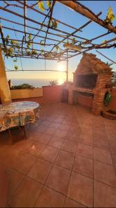 内比达Vista Sul Pan di Zucchero - Nebida - Holiday House的户外庭院设有石制壁炉和桌子。