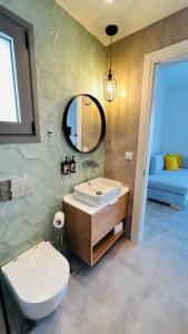 伊拉克里萨Arodo Suites的一间带水槽、卫生间和镜子的浴室