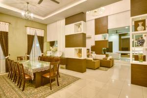 马六甲Elshape Holiday HOME的用餐室以及带桌椅的起居室。