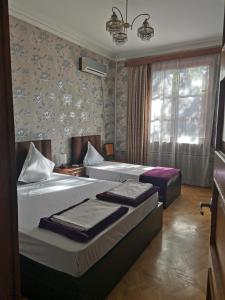 第比利斯EUROPEAN Backpackers Hostel的酒店客房设有两张床和窗户。