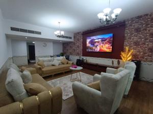 阿吉曼شقة كبيرة وفخمة large and luxury two bedroom的带沙发的客厅和砖墙上的电视