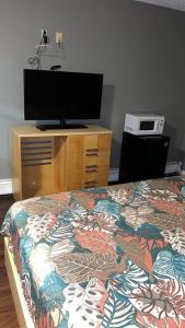 Maple Shade贝莱尔汽车旅馆的一间卧室配有一张床和一个带电视的梳妆台