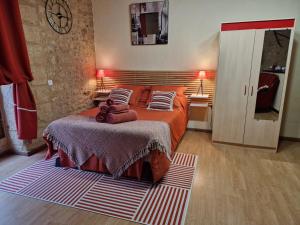 萨尔拉拉卡内达Les Flamboyants的一间卧室配有一张带红色床单和枕头的床。