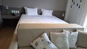 多明戈斯马丁斯Condomínio Vista Azul -CASA DOS CARDOSO的卧室内的一张带白色床单和枕头的大床