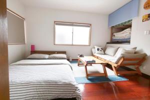 冈山冈山熊猫度假屋的小房间设有床和沙发
