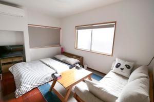 冈山冈山熊猫度假屋的客厅配有沙发和桌子