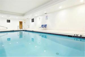 萨里Holiday Inn Express and Suites Surrey, an IHG Hotel的大型游泳池设有2把蓝色椅子
