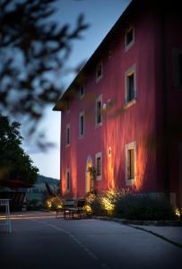 蓬塔谢韦Podere Belvedere Tuscany的一面有灯的红色建筑