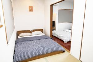 冈山冈山熊猫度假屋的一间小卧室,配有一张床和镜子