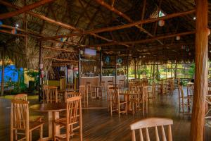 里约杜尔塞Banana Palms Hotel的一间带木桌椅的餐厅和一间酒吧