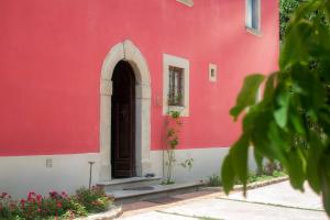 蓬塔谢韦Podere Belvedere Tuscany的红色和白色的建筑,有门