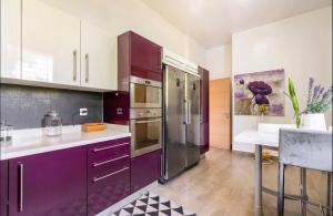 BouskouraVilla Eden luxe的厨房配有紫色橱柜和紫色冰箱