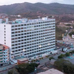 波拉马尔Hotel Faranda Express Puerta del Sol Porlamar的前面有一条街道的白色大建筑