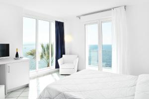 费尔蒂利亚格拉奇拉别墅酒店的白色卧室设有床、椅子和窗户