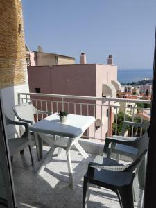 卡瓦拉Rafaela's Apartment的阳台上配有白色的桌椅