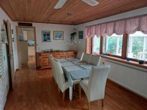 FunningsfjørðurFjord Guesthouse的一间带桌子和白色椅子的用餐室