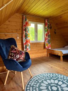 索利纳Domki letniskowe Stary dąb的一间带椅子和床的房间以及窗户