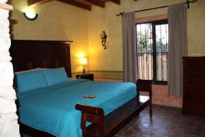 贝纳尔Hotel Casa Caro的一间卧室设有蓝色的床和窗户。
