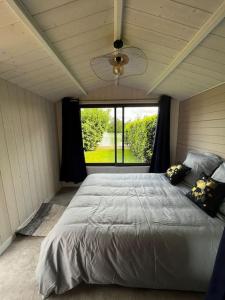 Saint-Sauveur-lès-BrayChalet moderne au bord d'un lac的一间卧室设有一张大床和大窗户