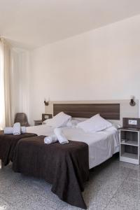 麦德林Mesón Hostal La Cabaña的两张位于酒店客房的床,配有毛巾