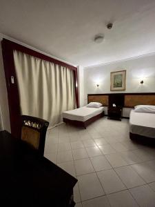 开罗The New Garden Palace Hotel的酒店客房设有两张床和一张桌子。