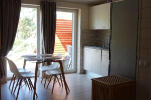 里加Holiday home near sea beach & pine forest的厨房配有桌椅和窗户。