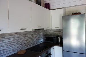 里加Holiday home near sea beach & pine forest的厨房配有白色橱柜和不锈钢冰箱
