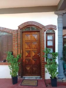 伊瓜苏港Flor de Lis的木门,房子上装有两盆植物