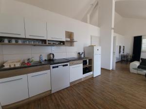 苏曼婷Apartmani Zen的厨房配有白色橱柜和白色冰箱。