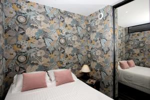 戛纳Appartement 5 min des plages Croisette的一间卧室设有两张床和花卉壁纸