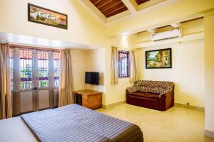 比纳里姆'Golden Oceans' 3 bhk beach view villa的卧室配有床、椅子和窗户。