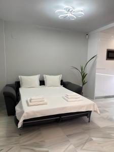 贝纳尔马德纳Luxury apartment Benalmadena First line的白色卧室设有一张白色天花板的床