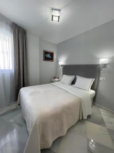 贝纳尔马德纳Luxury apartment Benalmadena First line的卧室配有一张带两个枕头的大白色床