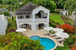 圣詹姆斯Royal Westmoreland, Royal Villa 1 by Barbados Sothebys International Realty的享有带游泳池和遮阳伞的房屋的空中景致