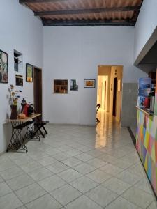 CampinasPouso das Artes Cachoeira-hospedaria e espaço cultural的客厅配有桌子,铺有瓷砖地板。
