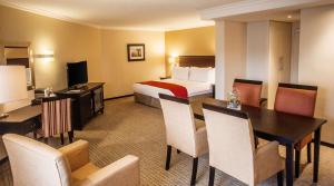 比勒陀利亚南孙比勒陀利亚酒店的酒店客房带一张床、一张桌子和椅子