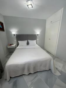 贝纳尔马德纳Luxury apartment Benalmadena First line的白色卧室配有白色的床和白色橱柜