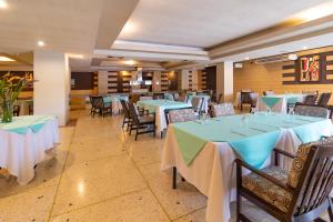 波拉马尔Hotel Faranda Express Puerta del Sol Porlamar的一间配备有桌椅及蓝白桌布的用餐室