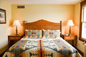 DepositChestnut Inn at Oquaga Lake的一间卧室配有一张大床和两盏灯