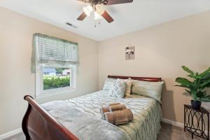 杰克逊维尔Quaint Jacksonville Getaway Near Camp Lejeune!的一间卧室配有一张带吊扇和窗户的床。