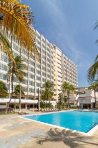 波拉马尔Hotel Faranda Express Puerta del Sol Porlamar的一座大型酒店,设有游泳池和棕榈树