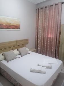 马尼塞斯Pensión A&E的卧室设有一张白色大床和一扇窗户。