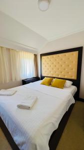 布德瓦Hotel Swiss Holiday的卧室配有一张带黄色枕头的大型白色床。