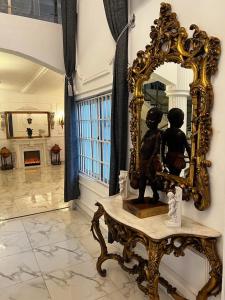 库马西The Peacock Mansion的镜子和一张桌子上的雕像