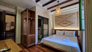 戈里察Bujtina Behram的卧室配有白色的床和砖墙