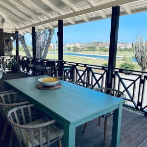 威廉斯塔德Villa at Blue Bay Resort with stunning view的门廊上的一张蓝色桌子,上面有椅子和碗