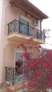 扎金索斯镇Bougainvillea apartment的一座带粉红色花卉阳台的建筑