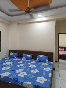 乌贾因Hanumant kripa geust house only for family的一间卧室配有一张蓝色床单和天花板